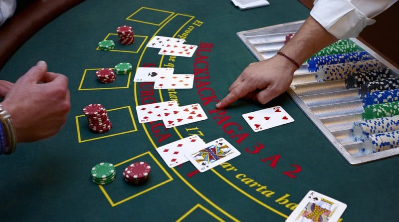 Blackjack-Spieltisch mit mehreren Spielern, offenen Karten und Einsätzen.